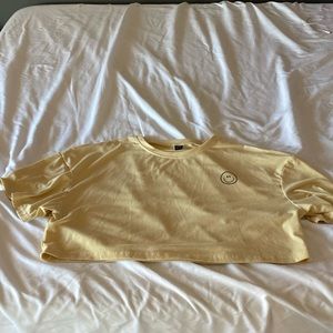 Pale yellow shein crop top with smiley face on it,